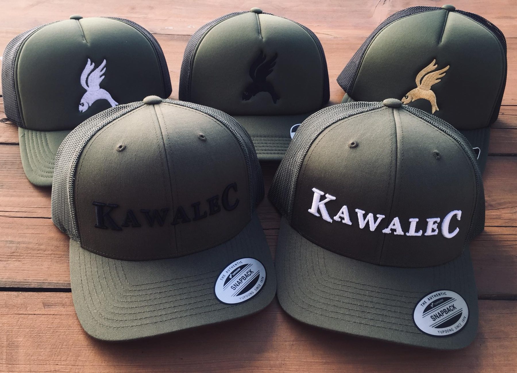 Czapki KawaleC — logo w bieli, czerni i złocie oraz napis w czerni i bieli